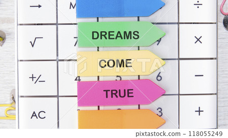 Conceptual dreams come true symbol. Copy space. Dreams come true words on the arrow-shaped stickers on the calculator 118055249