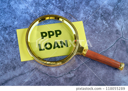 Paycheck Protection Program PPP Loan written through a magnifying glass on a yellow card on an abstract blue background Paycheck Protection Program PPP Loan written through a magnifying glass on a yellow card on an abstract blue background 118055289