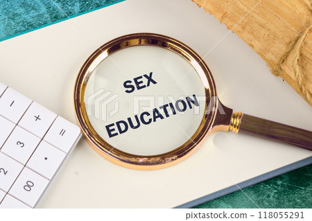 Sex education concept. SEX EDUCATION written through a magnifying glass in a business book Sex education concept. SEX EDUCATION written through a magnifying glass in a business book 118055291