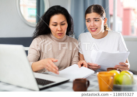 Women trying to solve document problem at home Women trying to solve document problem at home 118055327