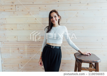 young brunette woman in black pants smiling 118056083