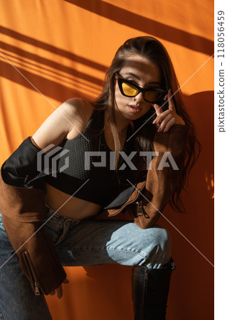 Beautiful fashionable slim woman wearing glasses, jeans and jacket Beautiful fashionable slim woman wearing glasses, jeans and jacket 118056459