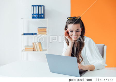 Business woman working on laptop online in office and smiling 118056478