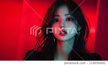 Korean woman with long hair wearing earrings poses against a vibrant red background in a modern setting 118056892
