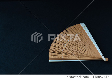 Japanese clothing accessory, folding fan, black background 118057616