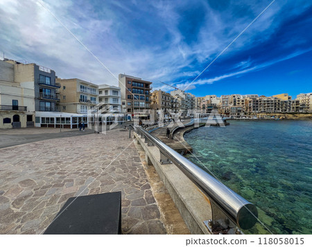View of the promenade in Marsalforn Bay  (Salt Pans) at Gozo, Malta at sunny day with some clouds 118058015