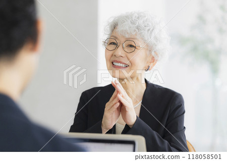 A senior woman operating a computer 118058501