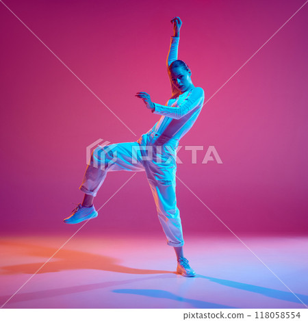 Display of rhythm and style. Young talented girl, dance in motion, training, performing hip-hop against pink background in neon light Display of rhythm and style. Young talented girl, dance in motion, training, performing hip-hop against pink background in neon light 118058554