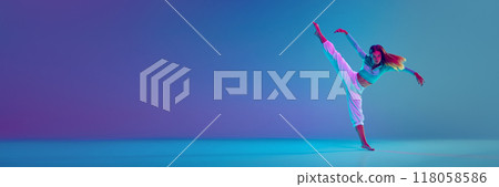 Flexible young girl, passionate hip hop dancer in motion on stage, performing against gradient blue background in neon light 118058586