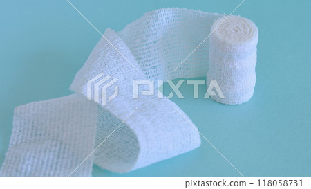 Image of bandages, essential for medical treatment of injuries, green background Image of bandages, essential for medical treatment of injuries, green background 118058731