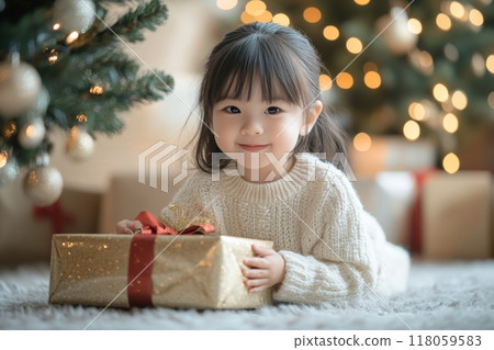 Happy Child Opening Gifts Under the Christmas Tree in a Cozy Modern Bright Interior 118059583