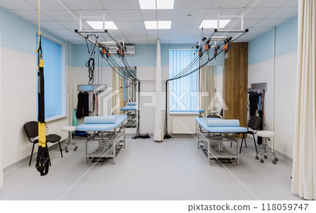 Rehabilitation room with therapy beds, suspension systems, and medical equipment for patient care 118059747