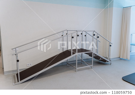 Rehabilitation room with parallel bars and equipment for physical therapy and mobility training 118059750