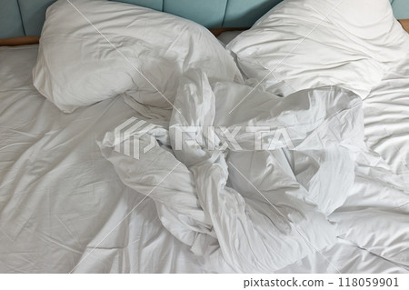 Messy hotel bed closeup 118059901