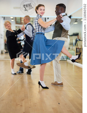 Woman with african man practising charleston dancing 118060502