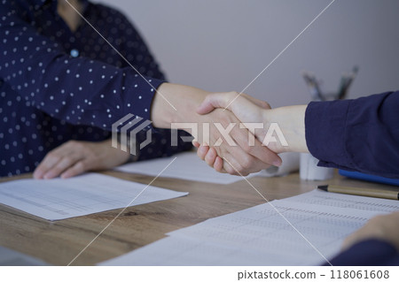 Accountants or auditors shaking hands after reviewing financial documents in office. Audit and taxes, handshake as a symbol of agreement 118061608