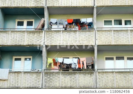 Balconies of panel building in ghetto with clothes hanging on ropes and drying. 118062456