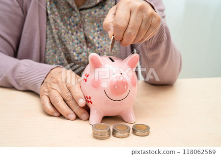 Asian elderly woman with pink piggy bank for saving money and insurance, poverty, financial problem in retirement. 118062569