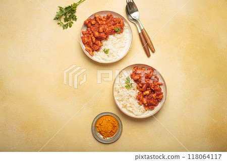 Indian chicken curry with rice and turmeric on yellow background with copy space top view Indian chicken curry with rice and turmeric on yellow background with copy space top view 118064117