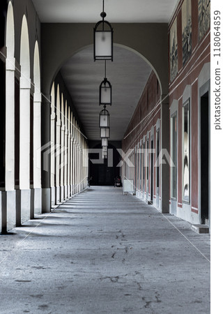 Long corridor with Antique lantern hanging from ceiling and Beautiful columns inside Hofgartenarkaden. 118064859