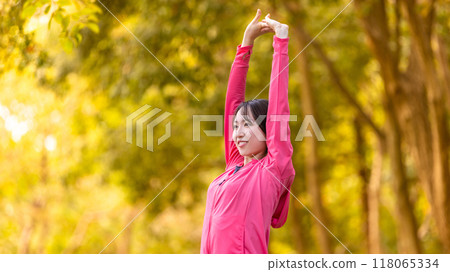 Sports autumn - Young woman stretching among autumn leaves Sports autumn - Young woman stretching among autumn leaves 118065334