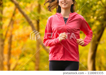 Sports autumn - Young woman jogging among autumn leaves 118065335