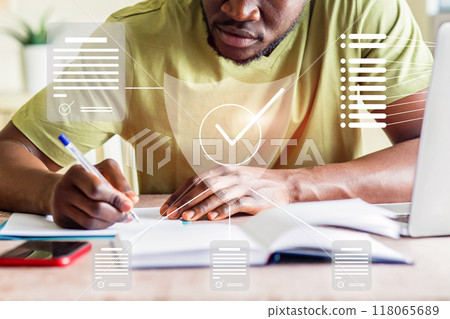 A man is writing on a piece of paper with a pen 118065689