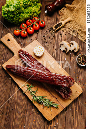 Smoked salami sticks on a wooden board, perfect for charcuterie boards and gourmet presentations Smoked salami sticks on a wooden board, perfect for charcuterie boards and gourmet presentations 118065916