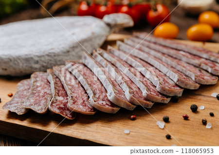 Close-up of sliced dry-cured salami on board, ideal for gourmet food and charcuterie presentations 118065953