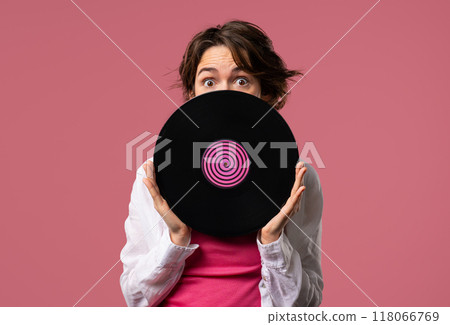 Positive short haired woman with vinyl record disc on pink. Hobby, music lover, collection, nostalgia lifestyle Positive short haired woman with vinyl record disc on pink. Hobby, music lover, collection, nostalgia lifestyle 118066769
