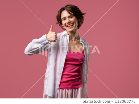 Positive woman with hand sign like, thumbs up gesture. Lady on pink background Positive woman with hand sign like, thumbs up gesture. Lady on pink background 118066773