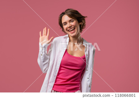 Friendly Young Adult Woman Waving Hand - Hello, Hi. Greetings. Pink Studio 118066801
