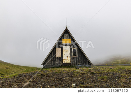 Small abandoned a-frame wooden hut standing on foggy day Small abandoned a-frame wooden hut standing on foggy day 118067350