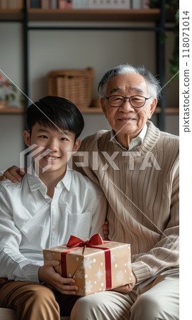A son gives his father a gift, beautifully packaged in a box. Strong family ties 118071014