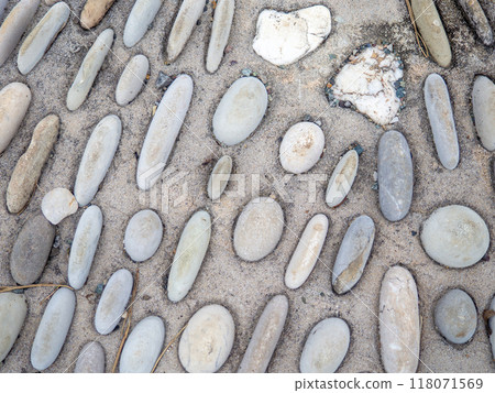 Pattern of sea stones in cement. Ground cover in the park. Background with bumps. Background of beach pebbles and concrete. Pattern of sea stones in cement. Ground cover in the park. Background with bumps. Background of beach pebbles and concrete. 118071569