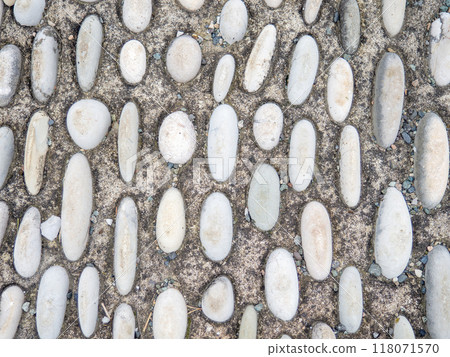 Pattern of sea stones in cement. Ground cover in the park. Background with bumps. Background of beach pebbles and concrete. 118071570