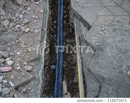 Broken sidewalk. Conducting the cable underground. Cable laying work. Communications in the city. Digging a trench for wires. Broken sidewalk. Conducting the cable underground. Cable laying work. Communications in the city. Digging a trench for wires. 118071671