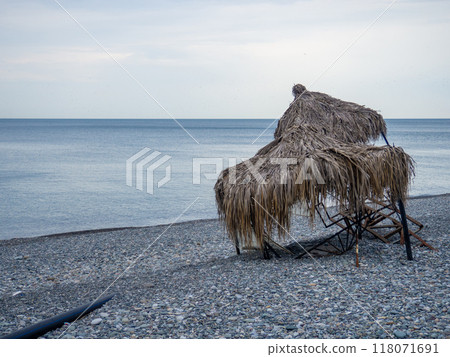 Beach houses with thatched roof in winter. Destroyed scenery on the beach. Beach houses with thatched roof in winter. Destroyed scenery on the beach. 118071691