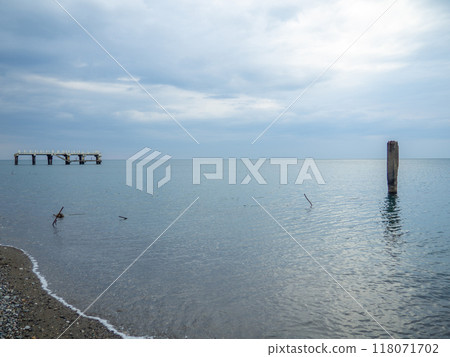 Reinforced concrete sticking out of the water. Remains of an old bridge in the sea. Ruined pier. Abandoned. Armature at sea. 118071702