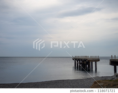 Reinforced concrete sticking out of the water. Remains of an old bridge in the sea. Ruined pier. Abandoned. Armature at sea. 118071721
