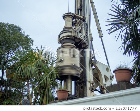 The work of the machine for drilling holes in the ground. Earth machine at work. Construction industry. The work of the machine for drilling holes in the ground. Earth machine at work. Construction industry. 118071777