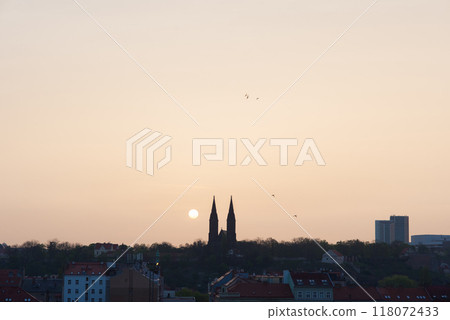 Morning sun rising among two church towers. Beautiful cozy sunrise over the city. 118072433