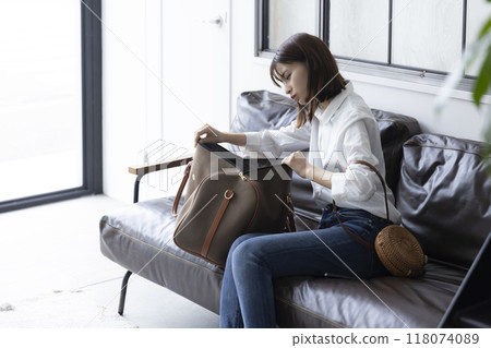 一位女士在她的包包裡搜尋 118074089