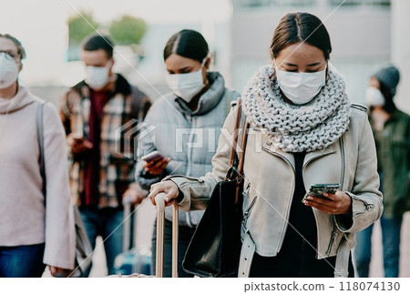 Home is never far away with wireless technology. Shot of a young woman using a smartphone and wearing a mask while travelling in a foreign city. Home is never far away with wireless technology. Shot of a young woman using a smartphone and wearing a mask while travelling in a foreign city. 118074130
