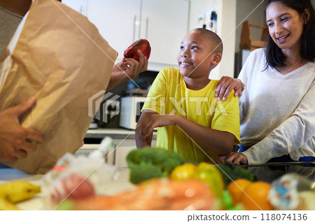 Whats for supper. Shot of a family unpacking the groceries in the kitchen at home. 118074136