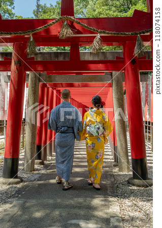 一對穿著浴衣的外國夫婦在鳥居林立的神社周圍散步 118074158