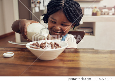 I like my breakfasts very milky. Cropped shot of an adorable little girl pouring milk into her cereal bowl at home. I like my breakfasts very milky. Cropped shot of an adorable little girl pouring milk into her cereal bowl at home. 118074288