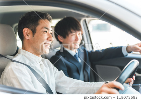 一位年輕的亞裔男性推銷員為前來選購、估價、購車的顧客服務。 一位年輕的亞裔男性推銷員為前來選購、估價、購車的顧客服務。 118075682