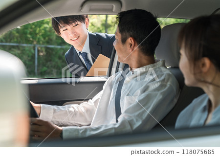 一位年輕的亞裔男性推銷員為前來選購、估價、購車的顧客服務。 118075685