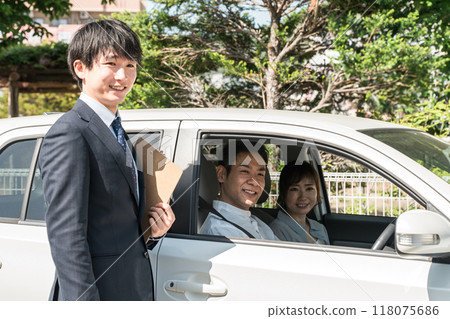 A young Asian male salesman serving customers who came to buy, assess and purchase a car 118075686